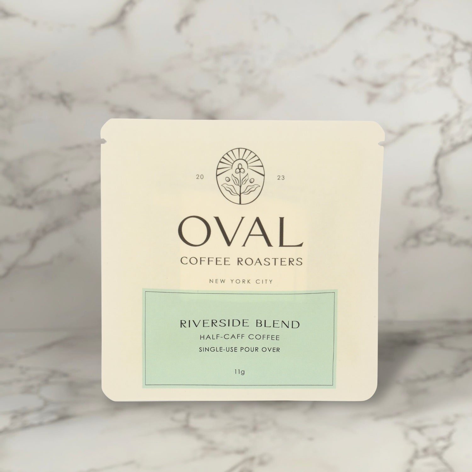 Oval Coffee Roasters Riverside Blend Half Caff single-serve 11g pour-over drip coffee packet — made with Swiss Water Process beans, highlighting the brand’s balanced light roast crafted with precision in New York City.