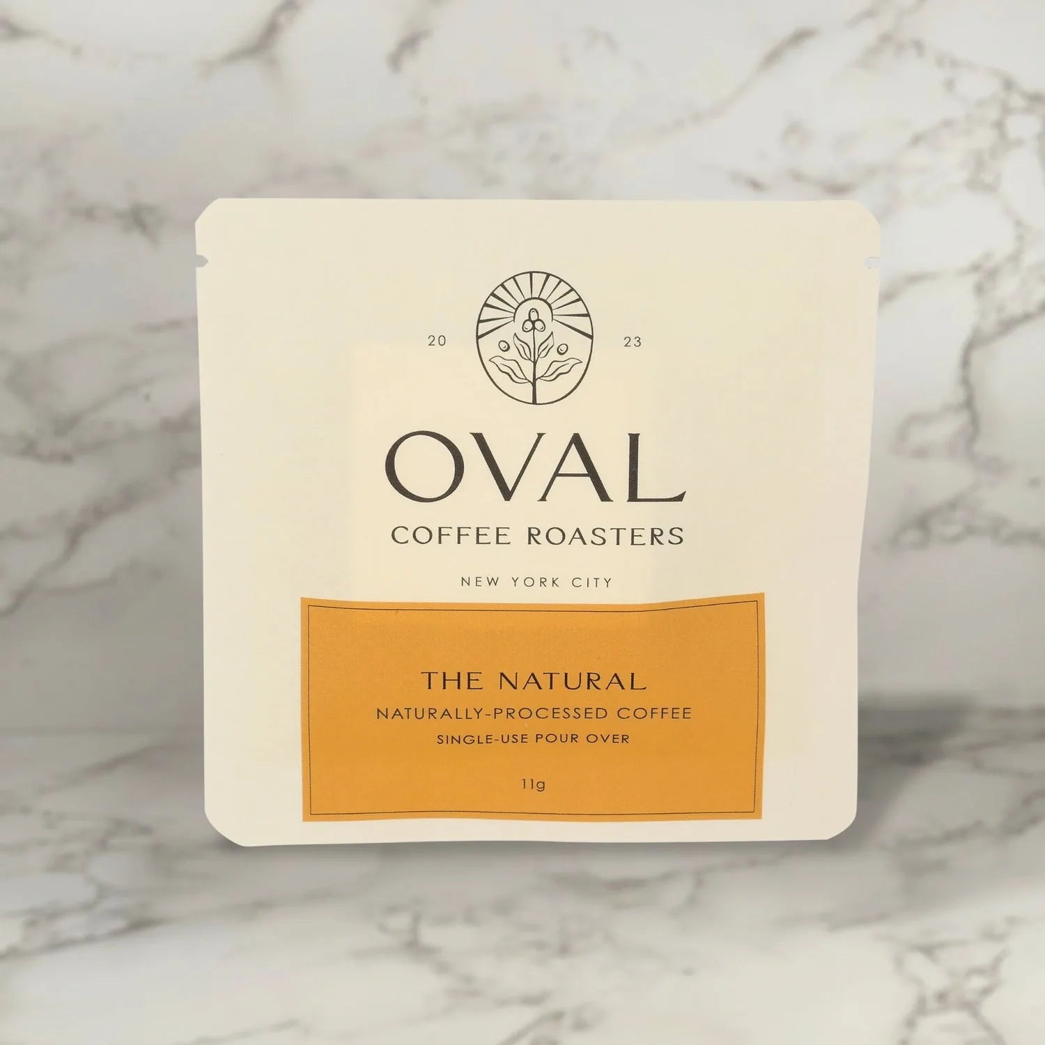 Oval Coffee Roasters The Natural 11g single-serve pour-over drip filter bag sleeve, naturally processed light roast coffee roasted in New York City, designed to brew directly over a cup without equipment
